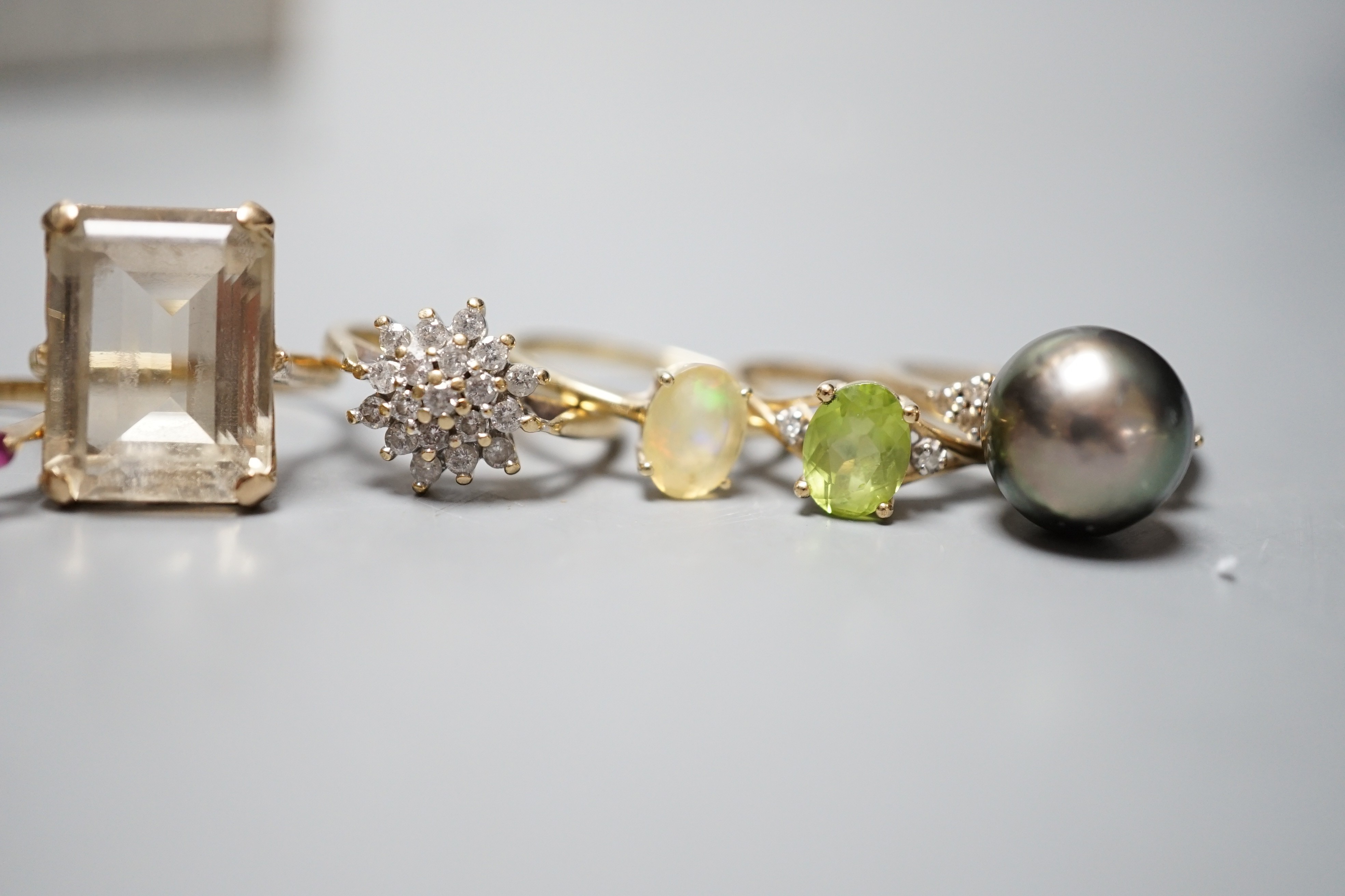 Seven assorted modern 9ct gold and gem set dress rings, including diamond cluster, white opal and white opal and ruby cluster, one stamped 9ct only.